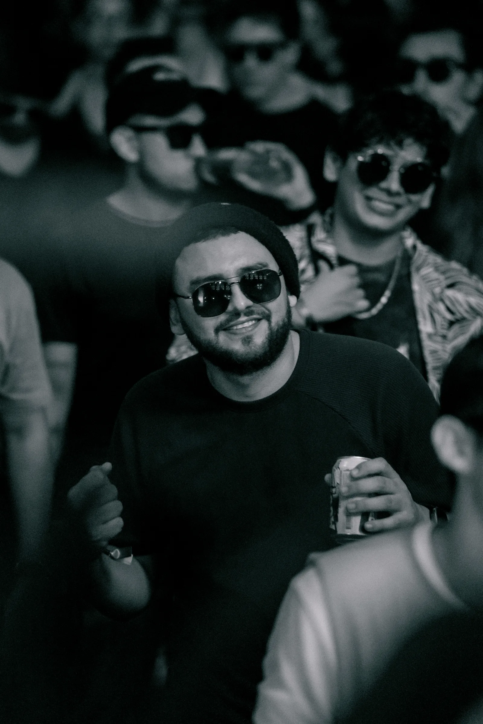 Asistente sonriendo entre el público en un retrato en blanco y negro