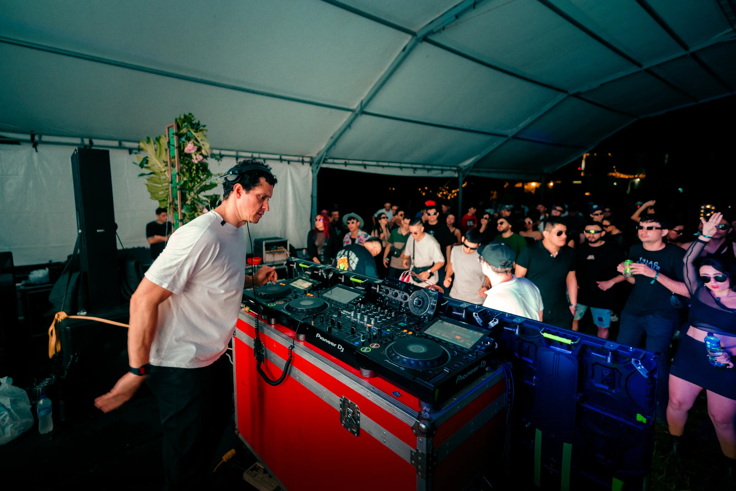 DJ en la cabina y público disfrutando la música