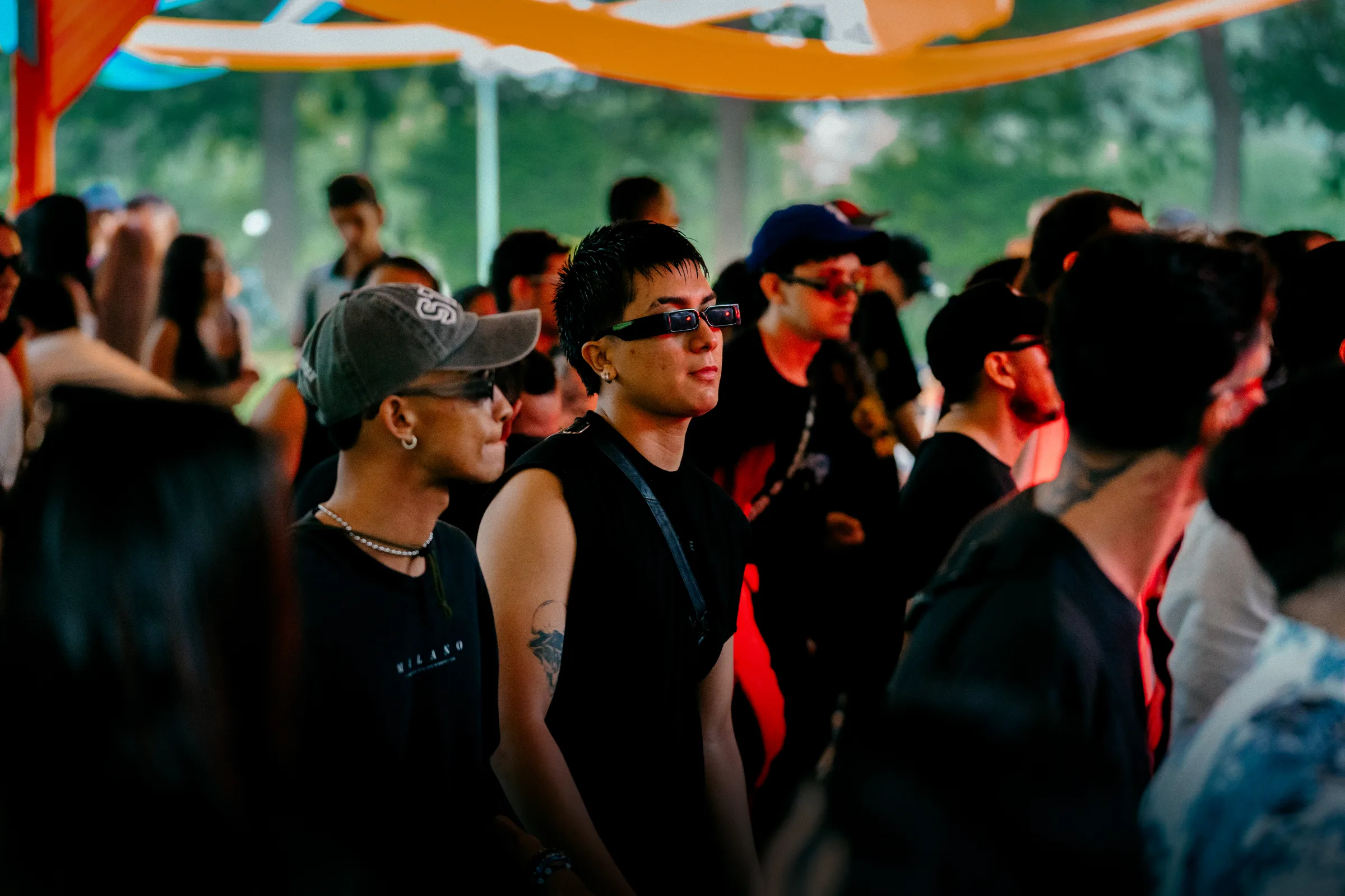 Público reunido bajo telas naranjas durante el festival